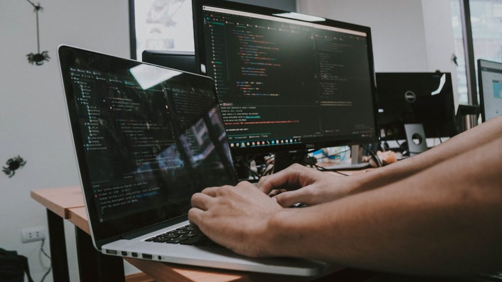 a-person-typing-on-a-laptop-computer-on-a-desk-uhx-ghppcdg